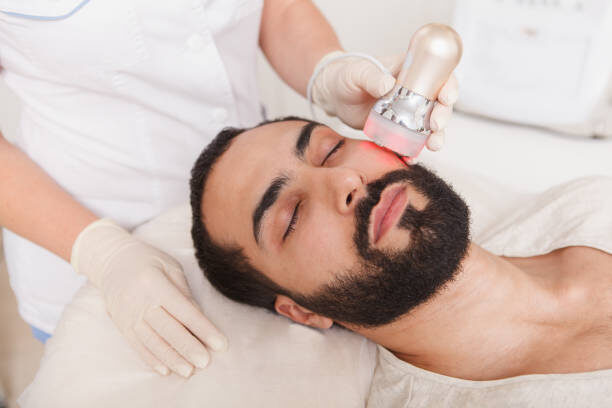 Close up of a male client relaxing during rf-lifting facial at beauty salon